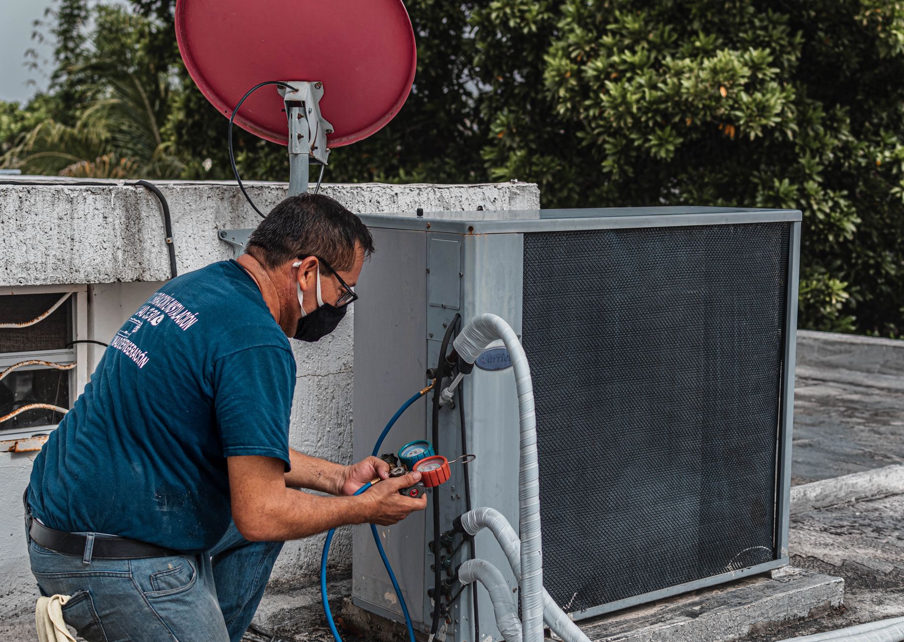 HVAC technician performing emergency AC repair on an outdoor unit in Dubai